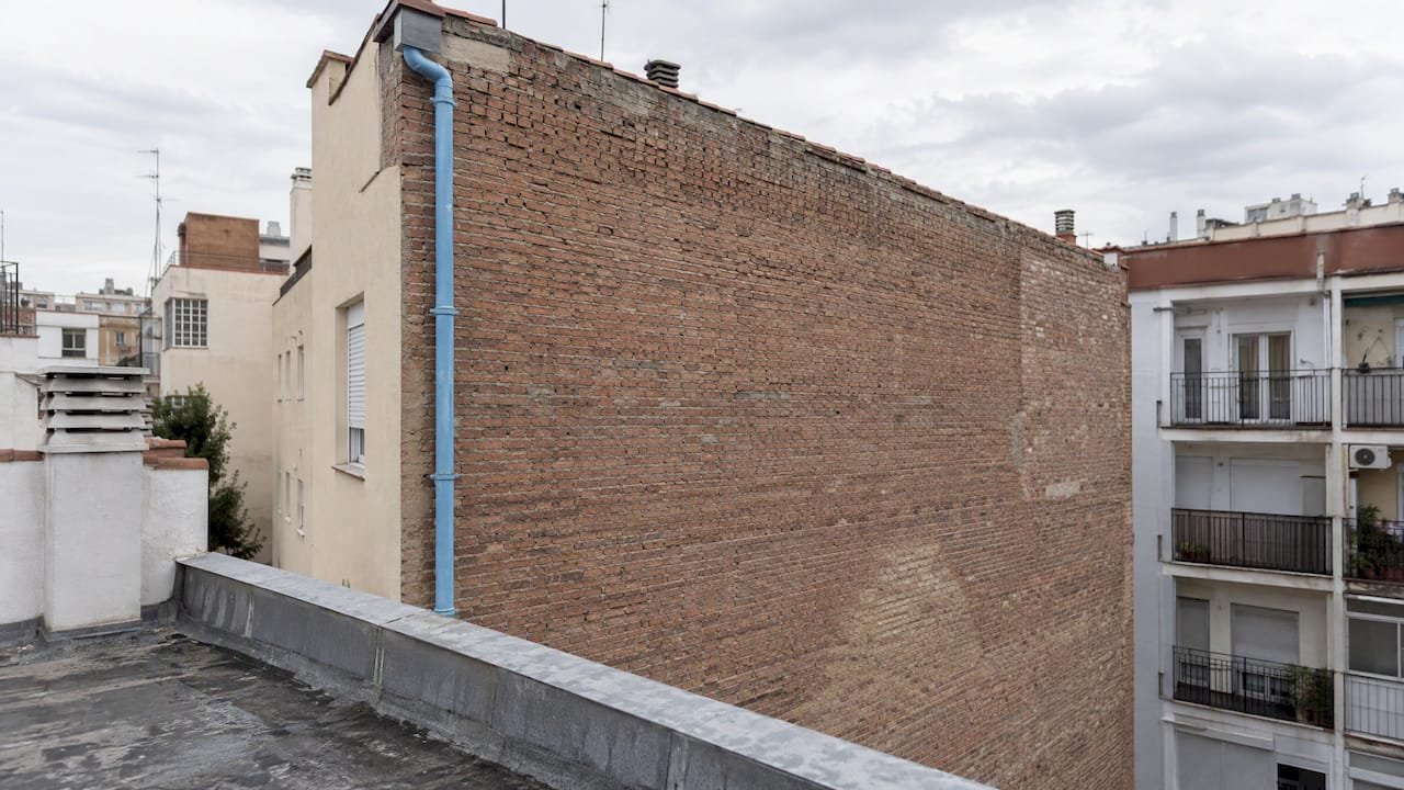 Muro de ladrillo visto entre edificios en Madrid